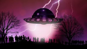 A UFO against a purple sky with silhouettes of people below.